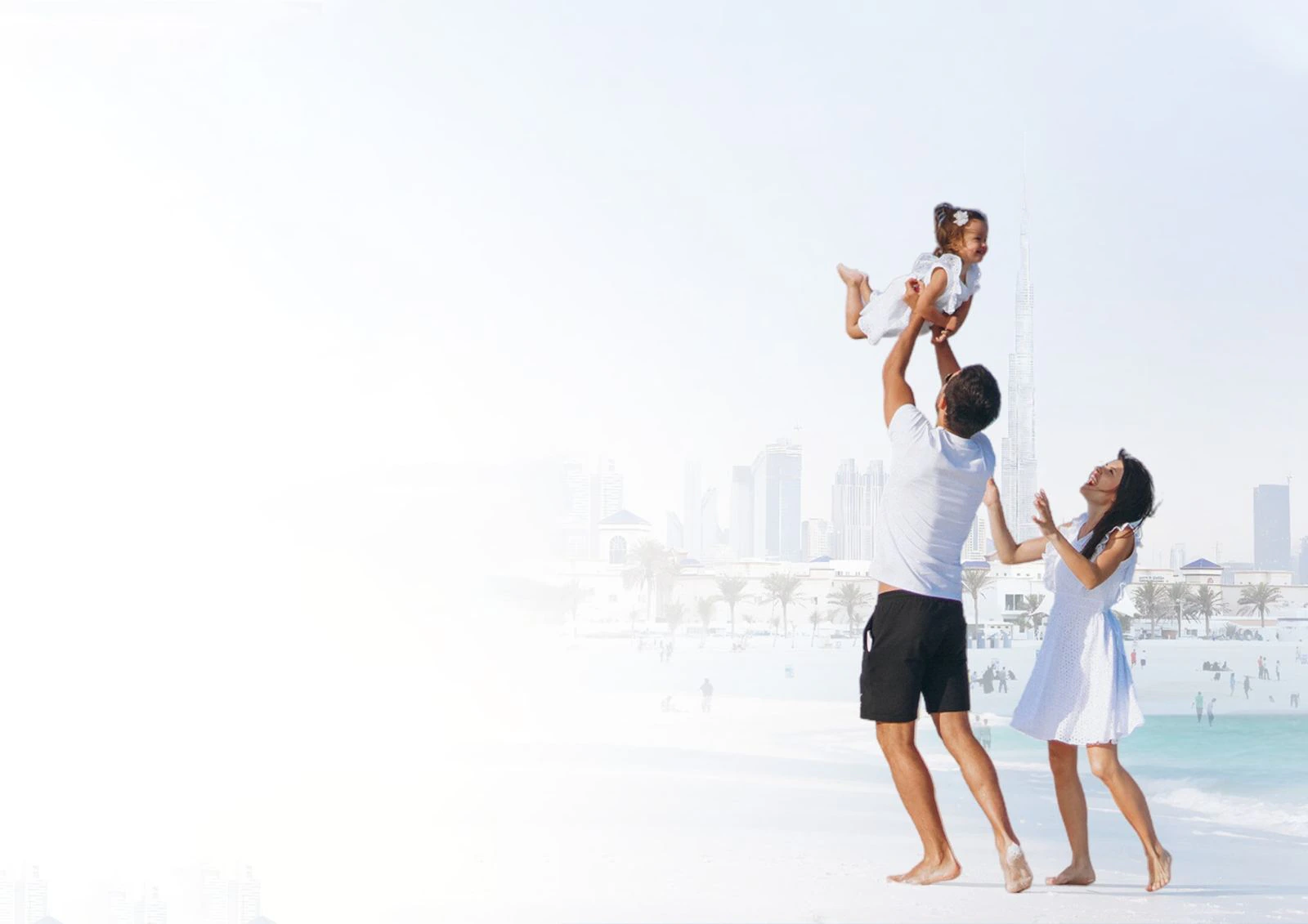 Family on a Dubai beach with the skyline behind them