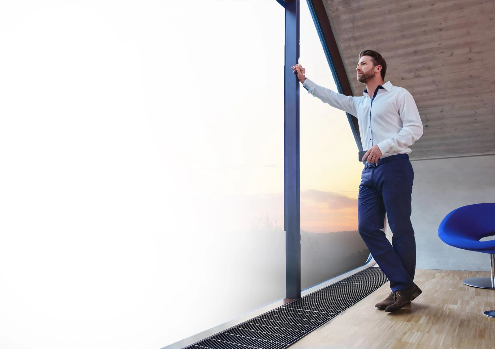 Professional looking out of an office window at sunset